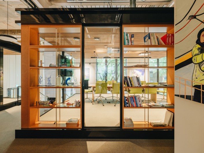 Glazed workspace and orange bookshelf at Hamburg ja Partnerid office