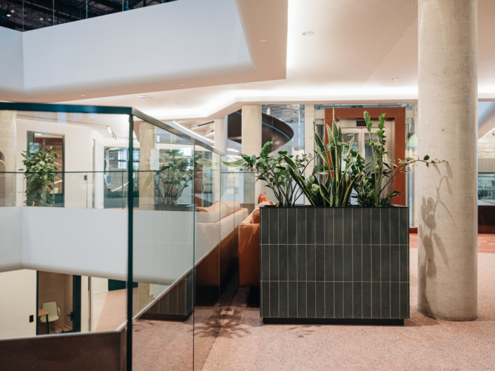 Glass balustrade and planter clad in green tiles at Nortal office