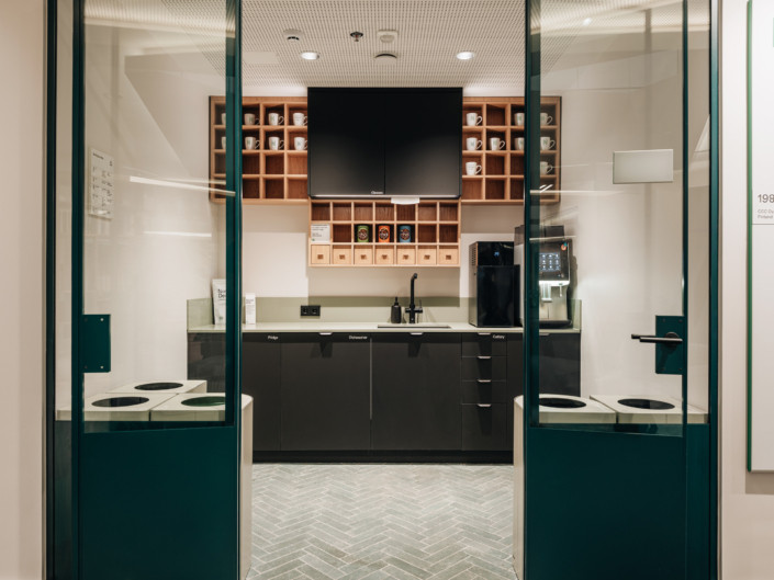 Kitchen with glass doors and black cabinetry at Nortal office