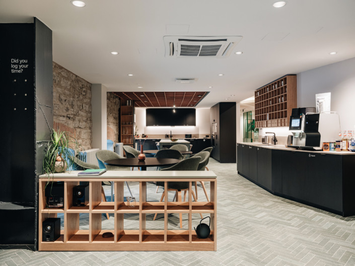 Kitchen and dining area with grey herringbone-pattern tiled flooring at Nortal office