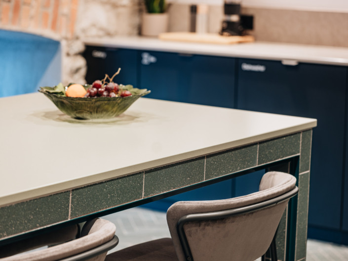 Close-up of the green-tiled edge of the kitchen island at Nortal office